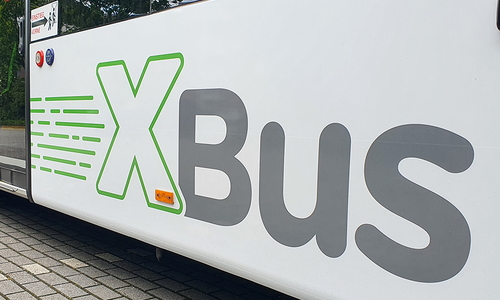 Seitenansicht eines Expressbusses mit der Aufschrift: XBus