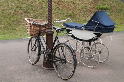 Fahrrad und Kinderwagen an einer Laterne