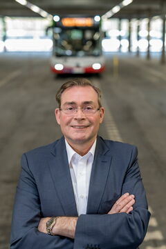 Thomas Krämer, Prokurist und Betriebsleiter, steht in der Wagenhalle vor einem Bus.