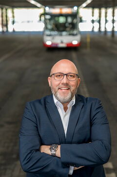 Torsten Kastner, Centerleiter Technik und stellvertretender Betriebsleiter, steht in der Wagenhalle vor einem Bus.