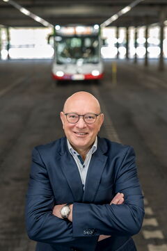 Thomas Mast, Prokurist und Centerleiter Finanzen und Rechnungswesen, steht in der Wagenhalle vor einem Bus.