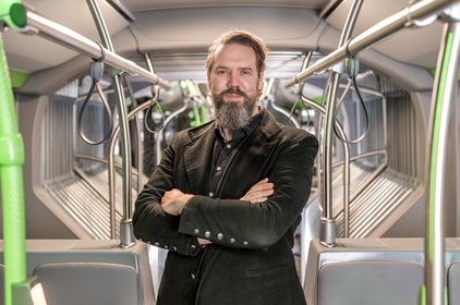 Pressesprecher Christoph van Bürk steht in einem Bus.