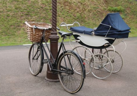Fahrrad und Kinderwagen an einer Laterne